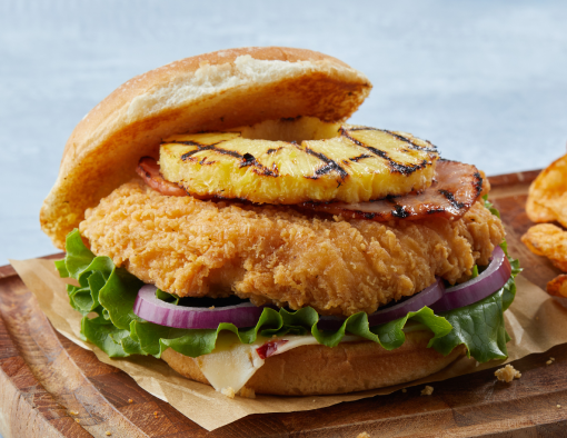 Sweet and Spicy Chicken Sandwich on a wood platter with a side of chips