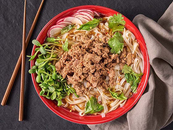 Pho recipe featuring Sliced Beef with spring vegetables, radish slices, fresh herbs, rice noodles and aromatic broth