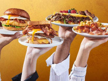 Hands holding breakfast plates.