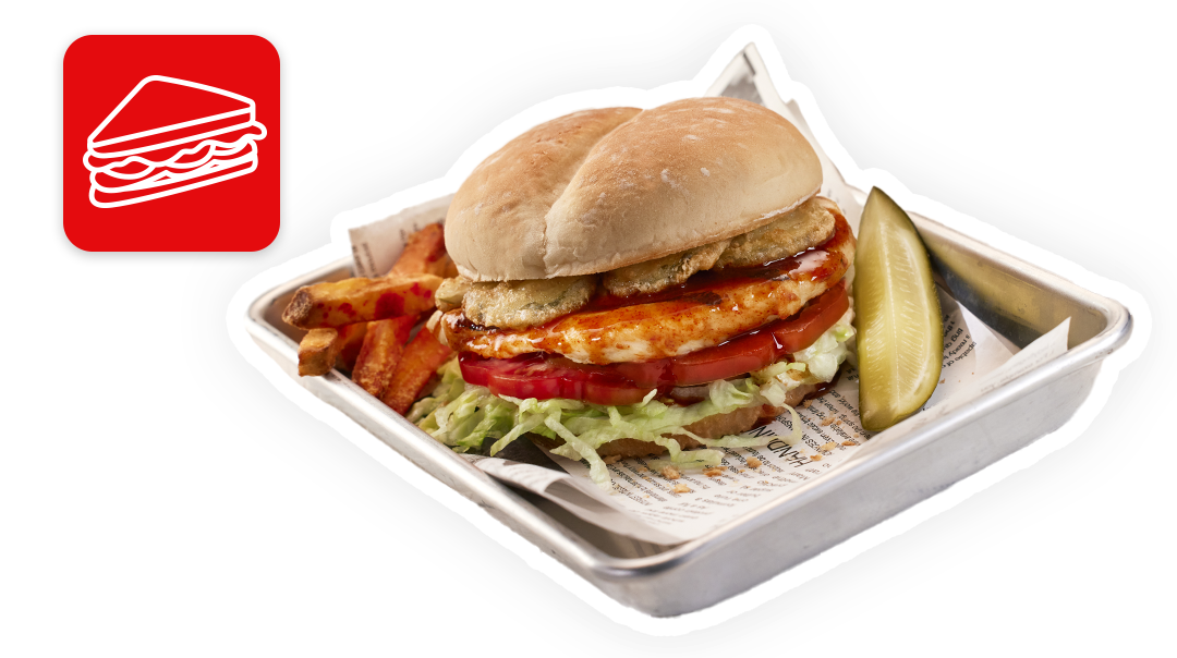 chicken sandwich, pickle and sweet potato fries in foodservice setting