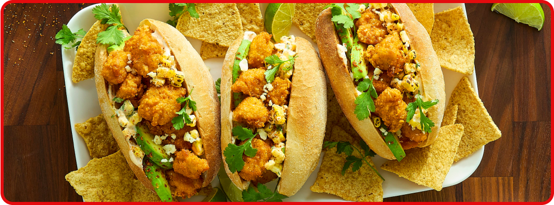 A plate of three tortas, each filled with hot honey chicken, roasted corn, avocado and chili. 
