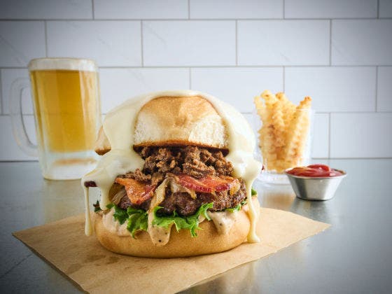 Double Steak Burger on Bun With Side of Fries and a Glass of Beer
