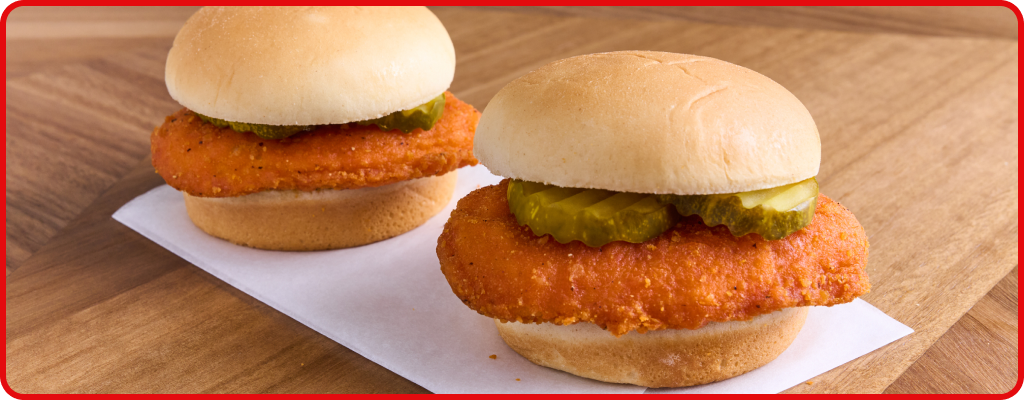 Chicken sandwich topped with pickles 