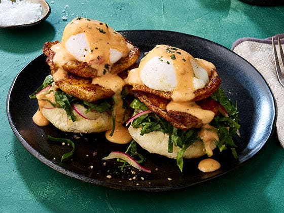 Charred pork fillets and poached eggs on southern-style biscuit with collard green slaw and fire roasted tomato hollandaise