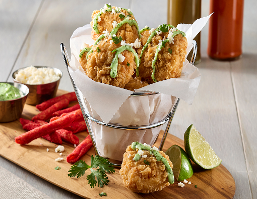 Basket of chicken tenders with a side of hot chips and sauces