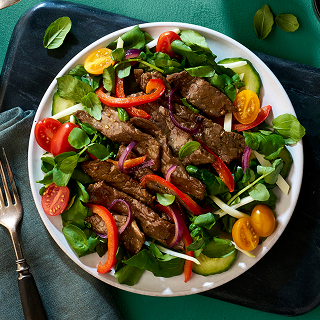 Sliced boneless bottom round on top of a salad