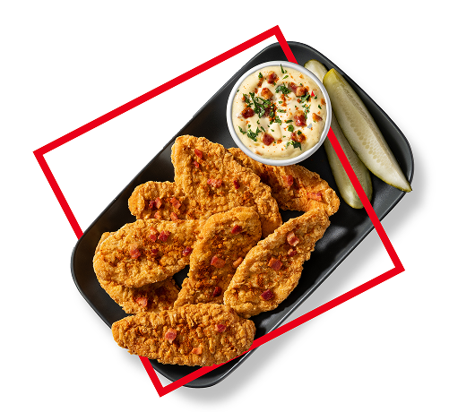 Chicken tenders on platter with pickles and side dish