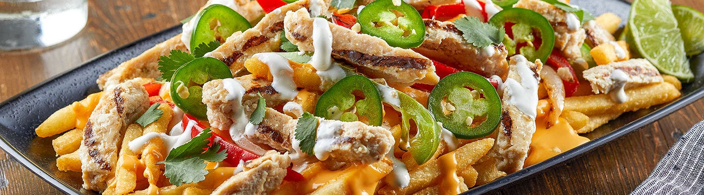 French fries topped with jalapenos, sliced chicken, sour cream and cheese