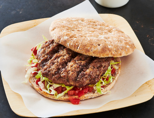 Grilled beef burger with tomato and red pepper relish and lemon turmeric slaw on a whole wheat flatbread 