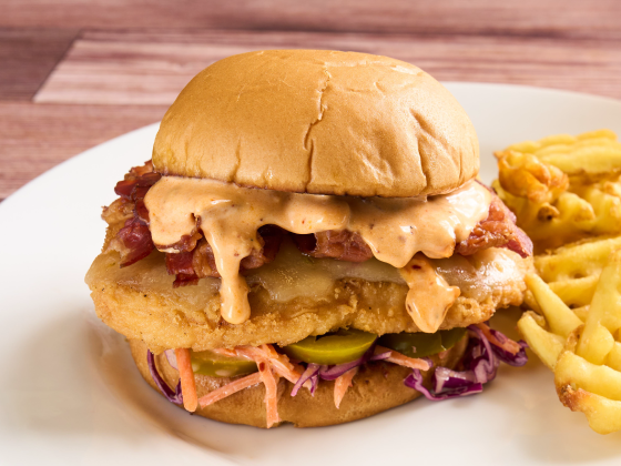 Chicken Bacon Chili Crunch Ranch Sandwich on a plate with a side of fries.