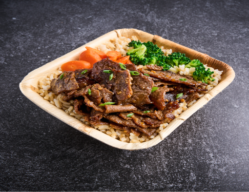 Rectangle bowl of sliced beef in sauce over rice with sliced carrots and broccoli 