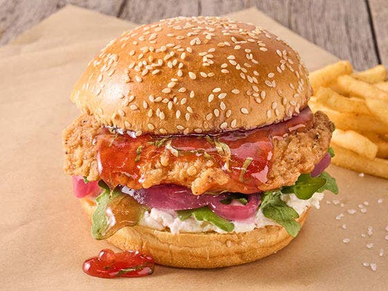 crispy chicken sandwich featuring Chicken Breast Filet layered with strawberry-basil jam, whipped goat cheese, fresh arugula and pickled red onion on a brioche bun