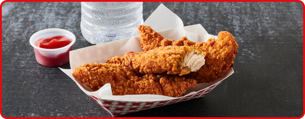 Chicken tenders in a basket with a side of ketchup