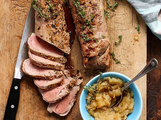 Grilled and Sliced Pork Tenderloin with Apple Onion Jam on a Board.