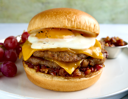 Breakfast Smash Burger recipe on a white plate with a side of grapes