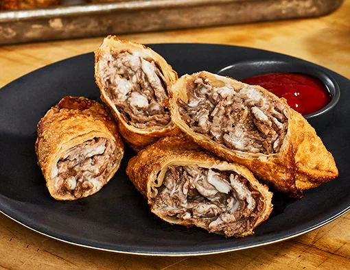 Beef Sandwich Slices with a mixture of white American cheese, garlic, and grilled onions and peppers wrapped up and browned