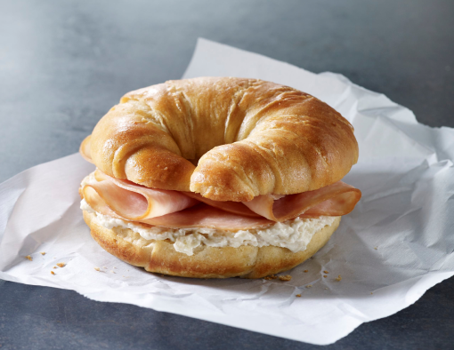 Ham slices on a croissant with cream cheese spread 