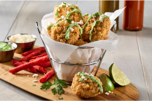 Basket of chicken tenders with a side of hot chips and sauces