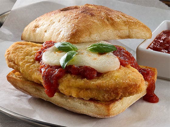 Chicken breast pattie with marinara sauce, mozzarella cheese and basil leaves on ciabatta bread
