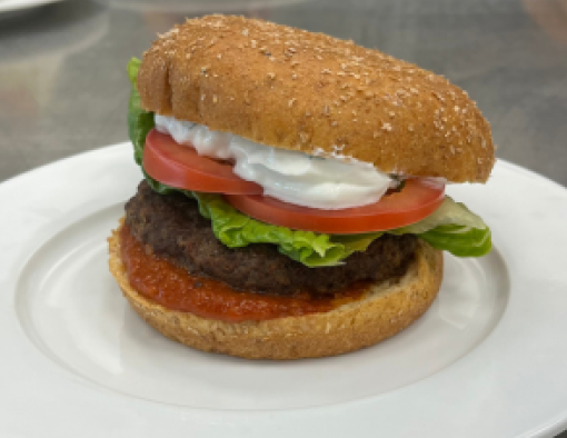 Grilled beef patty with tomato tikka masala sauce, lettuce, tomato slice and mint yogurt sauce 
