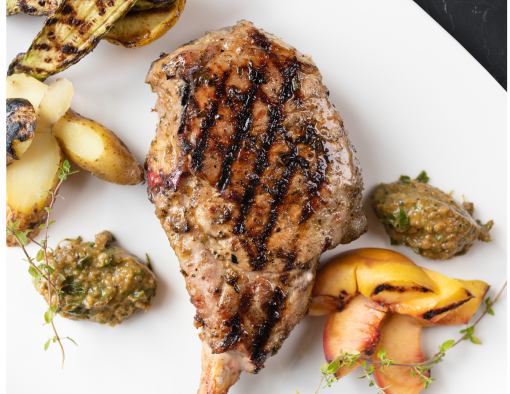 Peach Bourbon Tomahawd with a Lemon Wedge and Sides on a White Plate