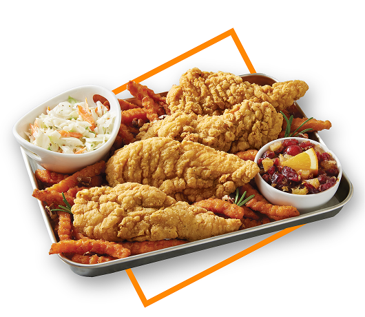 Chicken tenders on platter with sweet potato french fries and sides