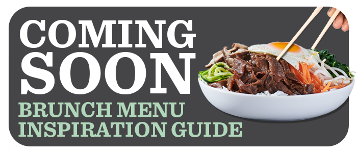 Hand using chopsticks for a heaping bowl of sliced beef, an over-easy egg, vegetables and noodles 