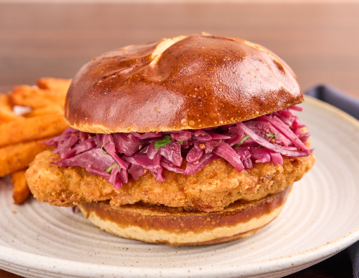 Crispy Chicken Schnitzel Sandwich Recipe on a white plate with a side of fries