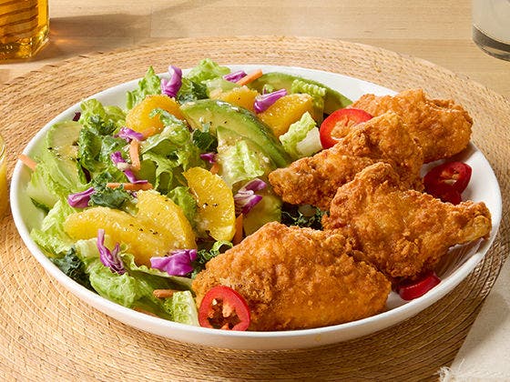 Crispy Tyson® Honey Stung® Jumbo Wings in a bowl of citrus avocado salad lime vinaigrette dressing