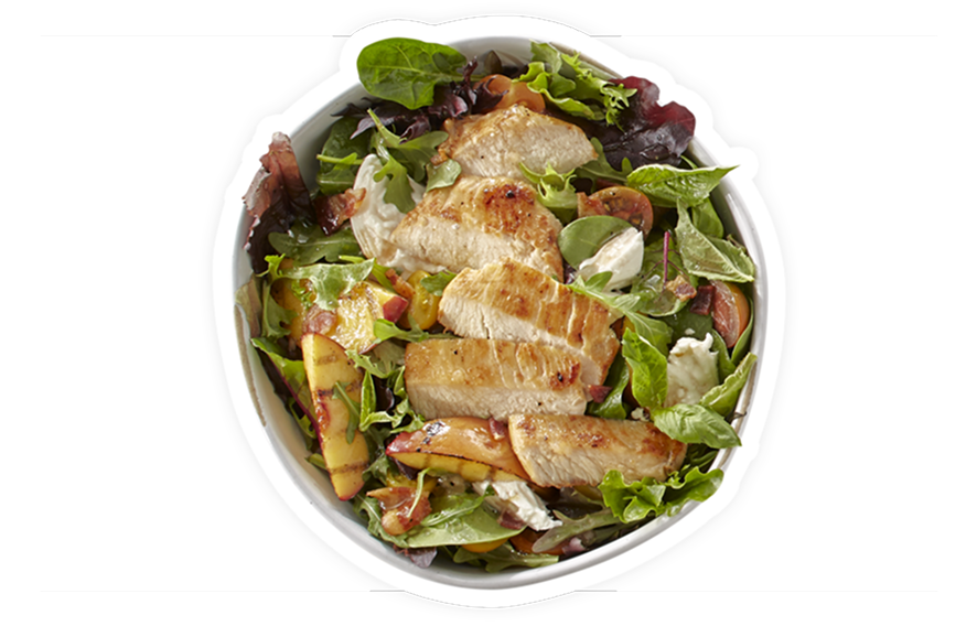 bowl with grilled chicken slices, fresh peach wedges, mixed greens, herbs, and creamy dressing