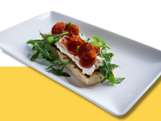 Ciabatta bread topped with ricotta cheese, pepperoni and arugula