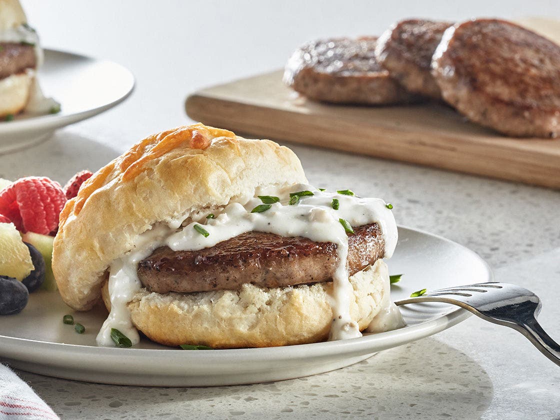 Sausage biscuit sandwich with gravy and chives.