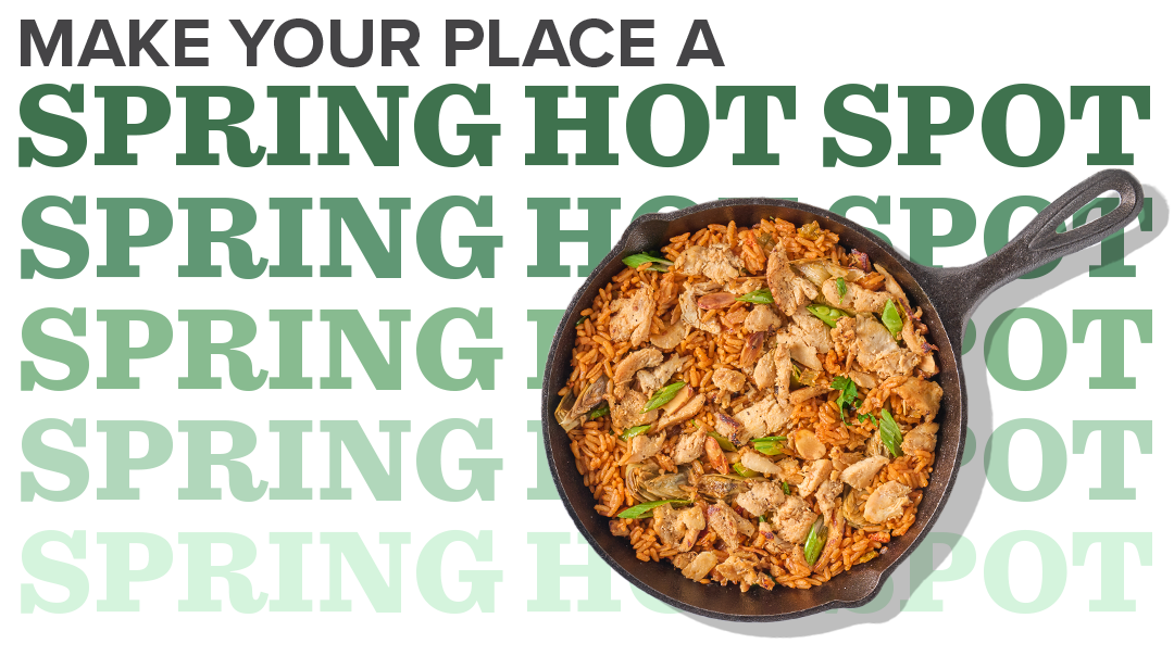 A cast-iron skillet of sliced chicken, artichoke hearts, peas and rice