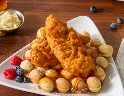 Crispy hot honey chicken and bubble waffles with berries, a delicious dish for brunch menus