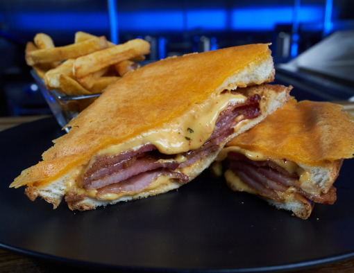 Hickory Smoked Thick Sliced Bacon on thick sliced toasted bread with kimchi aioli/mayo, double American cheese inside and crispy cheddar outside