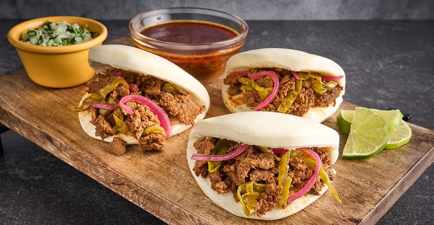 Bao buns filled with seasoned beef, pickled red onions, and jalapenos, served with dipping broth