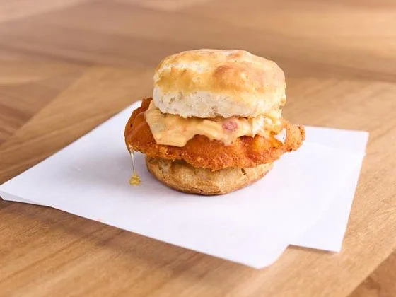 Southern chicken biscuit with crispy fried chicken patty and creamy pimento cheese on wooden table