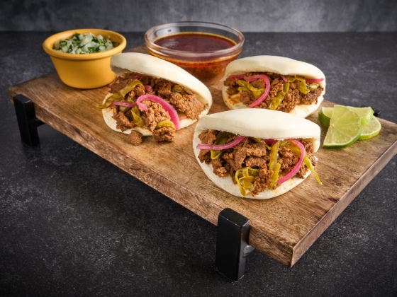 Bao buns filled with seasoned beef, pickled red onions, and jalapenos, served with dipping broth