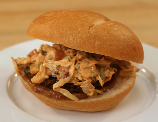 Grilled beef patty with Thai-style sauce and Thai slaw on a whole wheat bun 