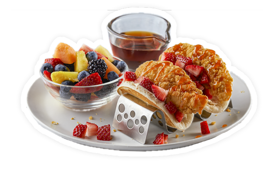 A plate of chicken tacos wrapped in a pancaked with a side of fruit